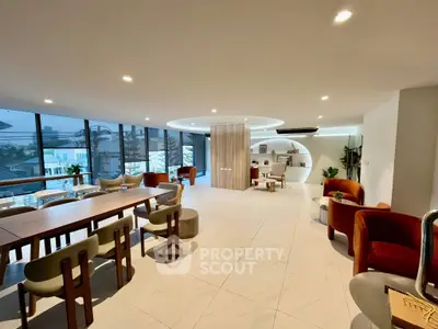 Spacious modern living area with elegant seating and large windows offering city views.