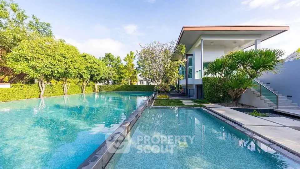 Luxurious modern home with stunning pool and lush greenery, perfect for relaxation and entertainment.