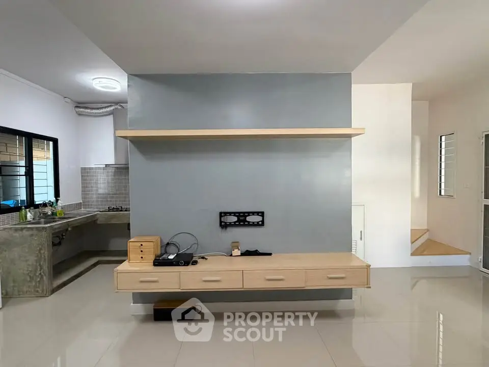 Modern open-layout living area with sleek kitchen and built-in storage