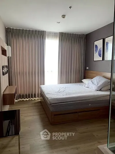 Spacious bedroom with modern decor and large window for natural light