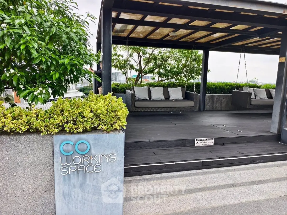 Stylish rooftop co-working space with modern seating and lush greenery, perfect for productivity and relaxation.