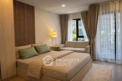 Modern bedroom with cozy decor, large window, and stylish furniture in a contemporary apartment.
