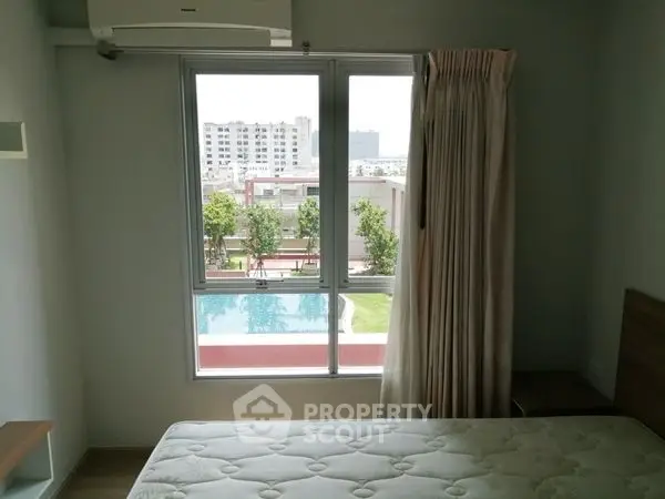 Modern bedroom with pool view, large window, and air conditioning unit.