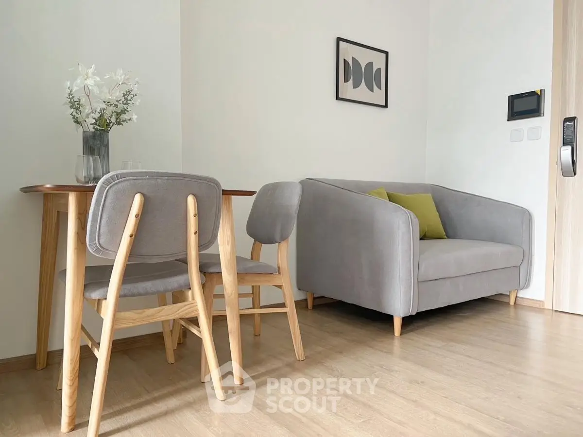 Modern living room with cozy gray sofa and stylish wooden dining set.