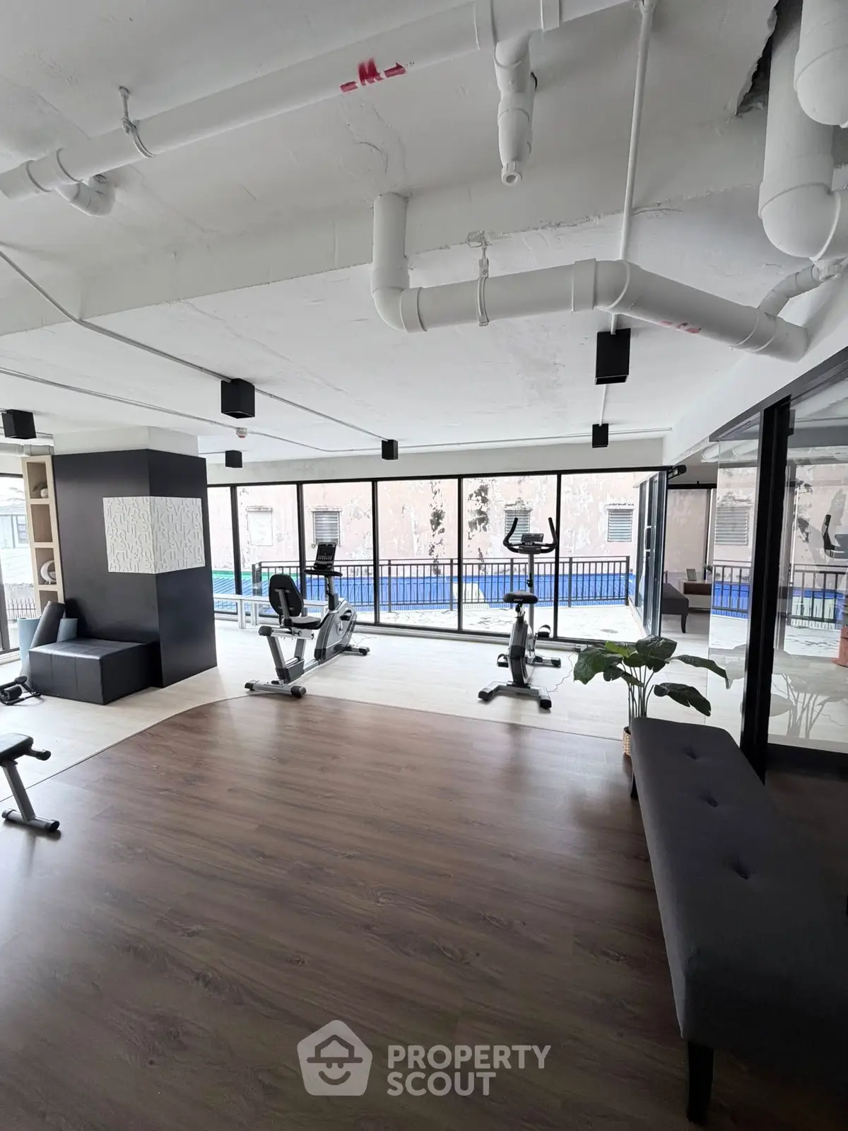 Spacious modern gym with large windows and exercise equipment