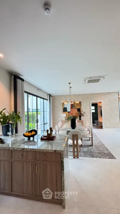 Luxurious open-plan living and dining area with elegant decor and large windows.
