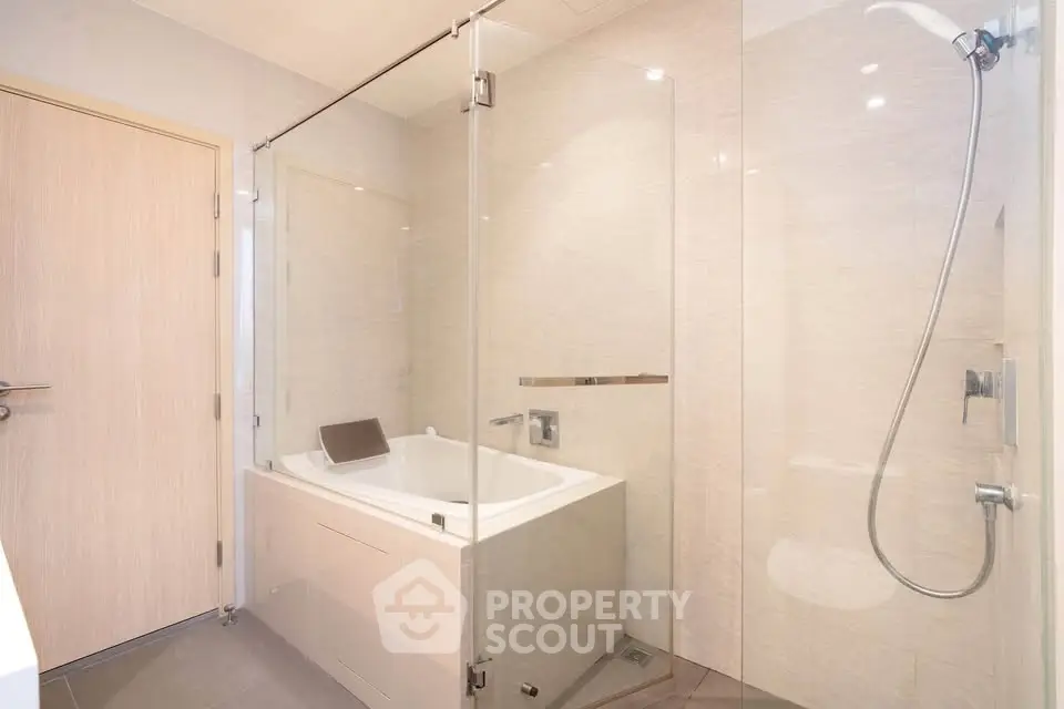 Modern bathroom with glass shower and bathtub in luxury apartment
