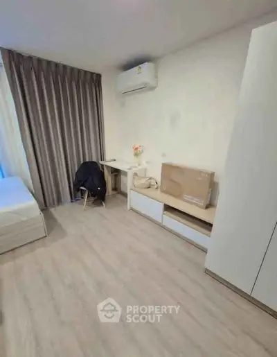 Modern bedroom with minimalist decor, featuring air conditioning and sleek furniture.