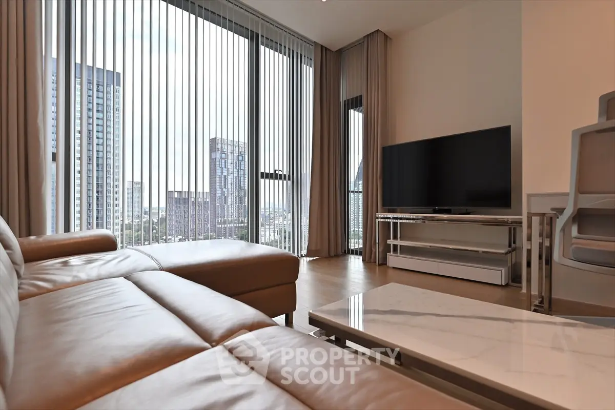 Modern living room with leather sofa and city view through large windows