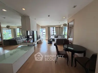 Spacious modern living room with elegant furniture and large windows offering city views.
