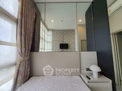 Modern bedroom with mirrored wall and stylish decor