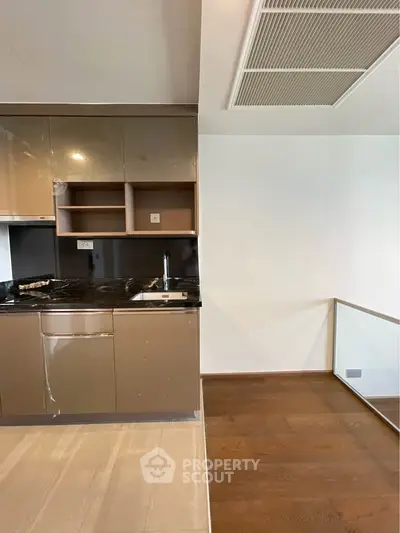 Modern kitchen with sleek cabinetry and wooden flooring in a contemporary home.