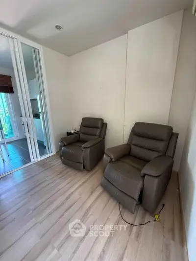 Cozy living room with two leather recliners and wooden flooring