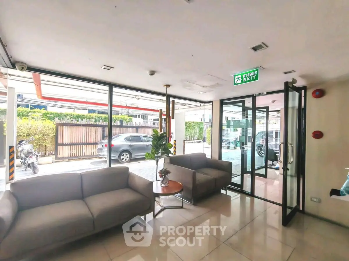 Modern building entrance with glass doors and cozy seating area