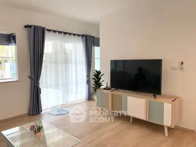 Modern living room with stylish TV stand and large windows with curtains.