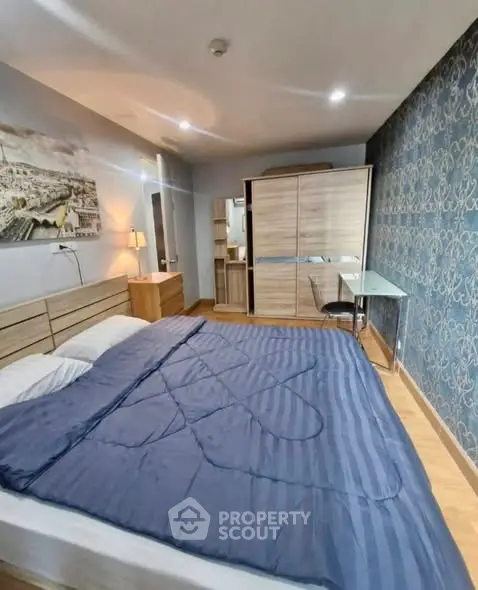 Modern bedroom with stylish decor and ample storage space in a cozy apartment.