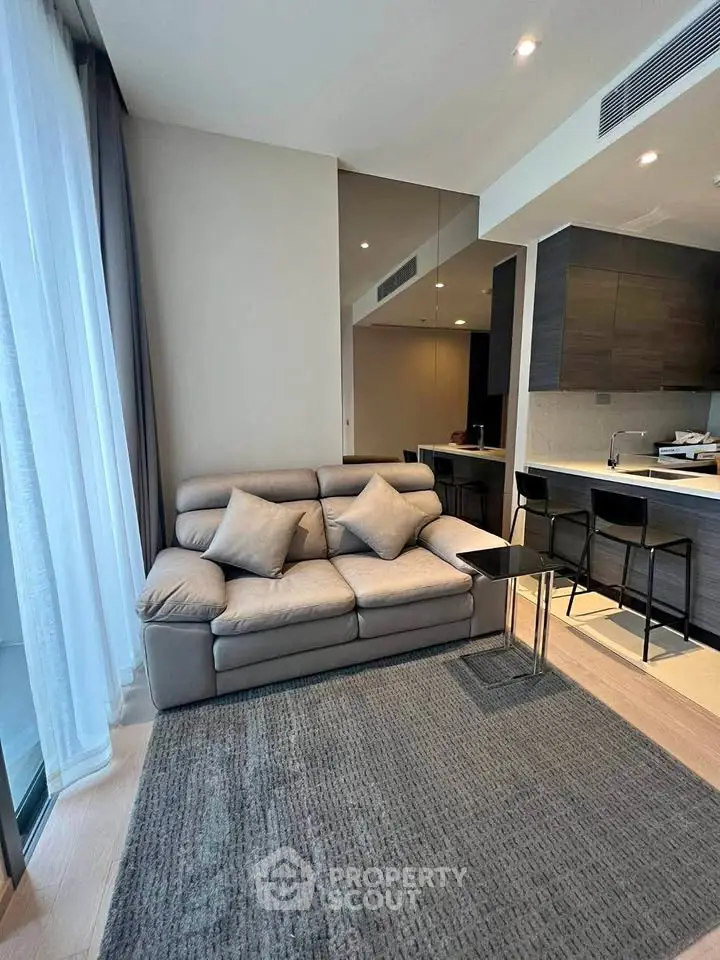 Modern living room with cozy sofa and open kitchen layout in stylish apartment