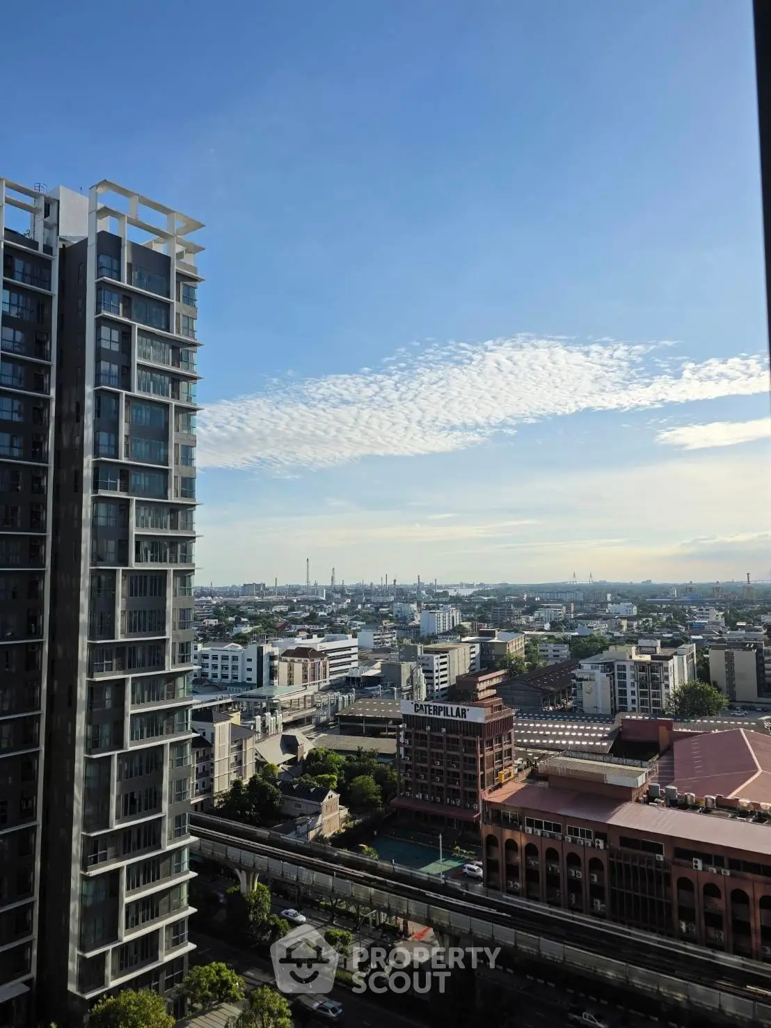 Stunning cityscape view from high-rise building with clear blue sky and urban skyline.