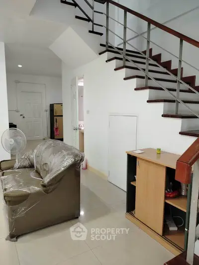 Modern interior with staircase and cozy living area, perfect for urban living.