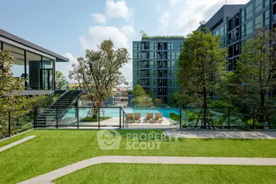 Modern apartment complex with pool and lush greenery, offering a serene urban oasis.
