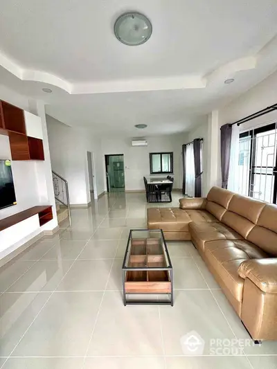 Spacious modern living room with leather sofa and glass coffee table