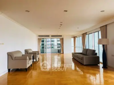 Spacious living room with elegant parquet flooring and modern furniture in a high-rise apartment.