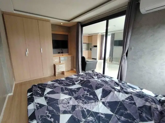 Modern bedroom with stylish decor and large window offering natural light.