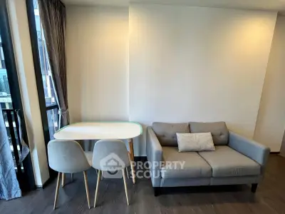 Modern living room with cozy sofa and dining table near large window.