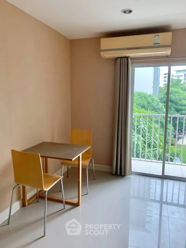 Cozy dining area with natural light and balcony view in modern apartment.