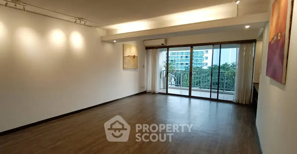 Spacious living room with large windows and balcony access in modern apartment.