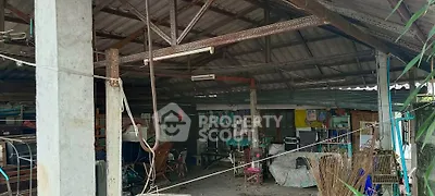 Spacious rustic open-air structure with exposed beams and eclectic decor, ideal for creative renovation.