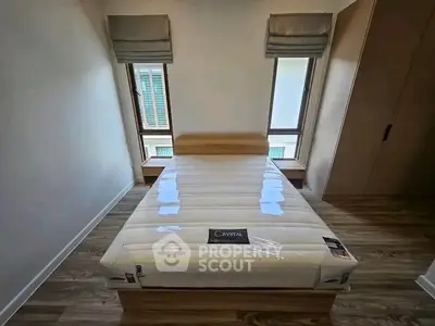 Modern bedroom with sleek wooden flooring and stylish bed setup, perfect for cozy living.