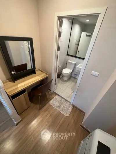 Cozy bedroom with ensuite bathroom featuring modern fixtures and wooden flooring.