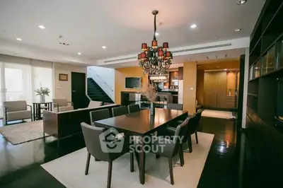 Luxurious open-plan living and dining area with elegant chandelier and modern furnishings.