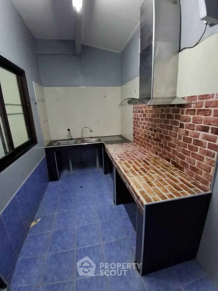 Modern kitchen with brick backsplash and blue tiled floor