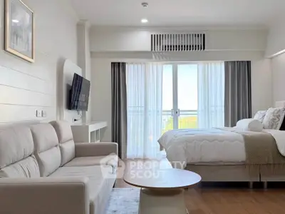 Modern studio apartment with cozy living area and bed, featuring a balcony with a scenic view.