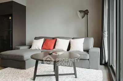 Modern living room with stylish gray sofa, floor lamp, and large windows for natural light.