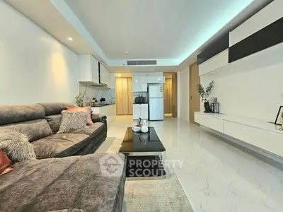 Spacious modern living room with plush sofa and sleek kitchen area