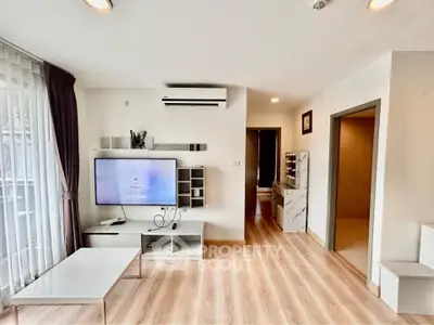 Modern living room with sleek design, featuring a wall-mounted TV, air conditioning, and stylish decor.