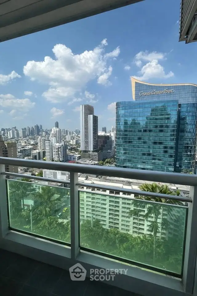 Stunning cityscape view from a high-rise balcony with modern skyline and clear blue sky.