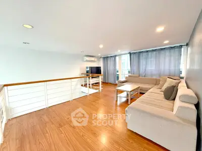 Spacious modern living room with wooden flooring and stylish furniture in a bright, airy setting.