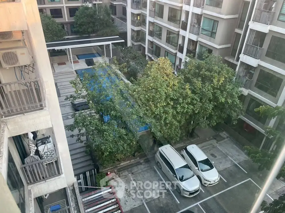 Modern apartment complex with pool and parking view from upper floor.