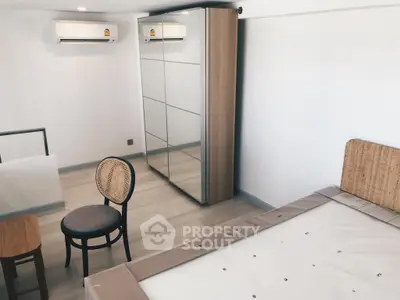 Modern bedroom with mirrored wardrobe and air conditioning unit