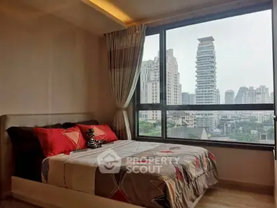 Modern bedroom with large window offering stunning city view in high-rise apartment.