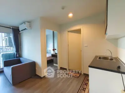 Modern apartment interior with cozy living room and compact kitchen, featuring sleek design and natural light.