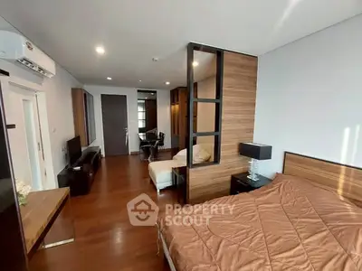 Spacious modern bedroom with wooden flooring and stylish decor