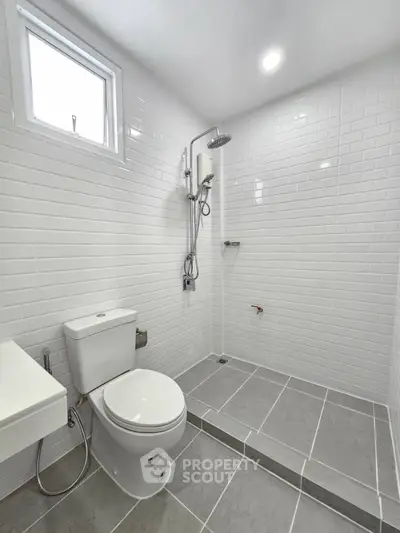 Modern bathroom with sleek white tiles and walk-in shower