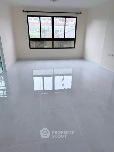 Spacious empty room with large window and glossy tiled floor, perfect for customization.