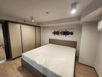 Spacious modern bedroom with large wardrobe and stylish cityscape artwork.