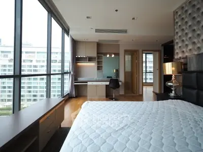 Luxurious modern bedroom with large windows and city view in high-rise apartment